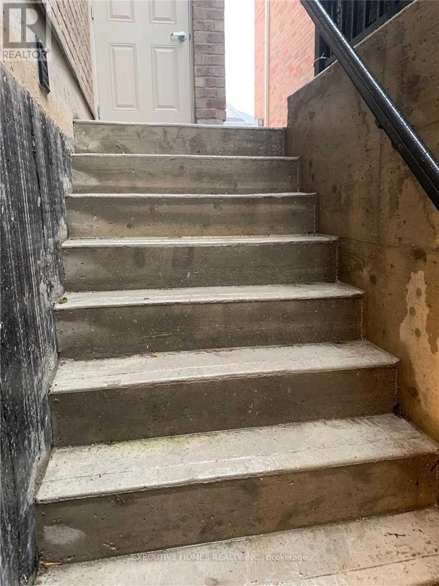 A set of concrete stairs with a metal railing on the side.