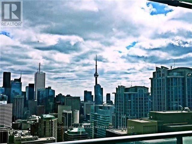 A cityscape with a mix of modern and older buildings under a cloudy sky.