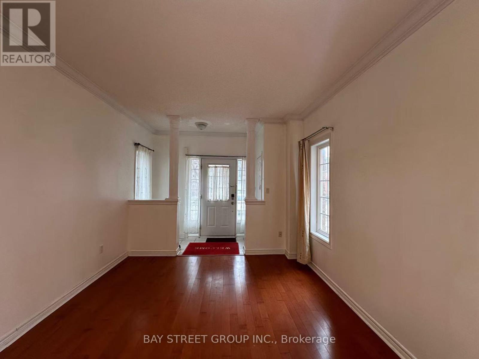 A spacious room with wooden floors and white walls.