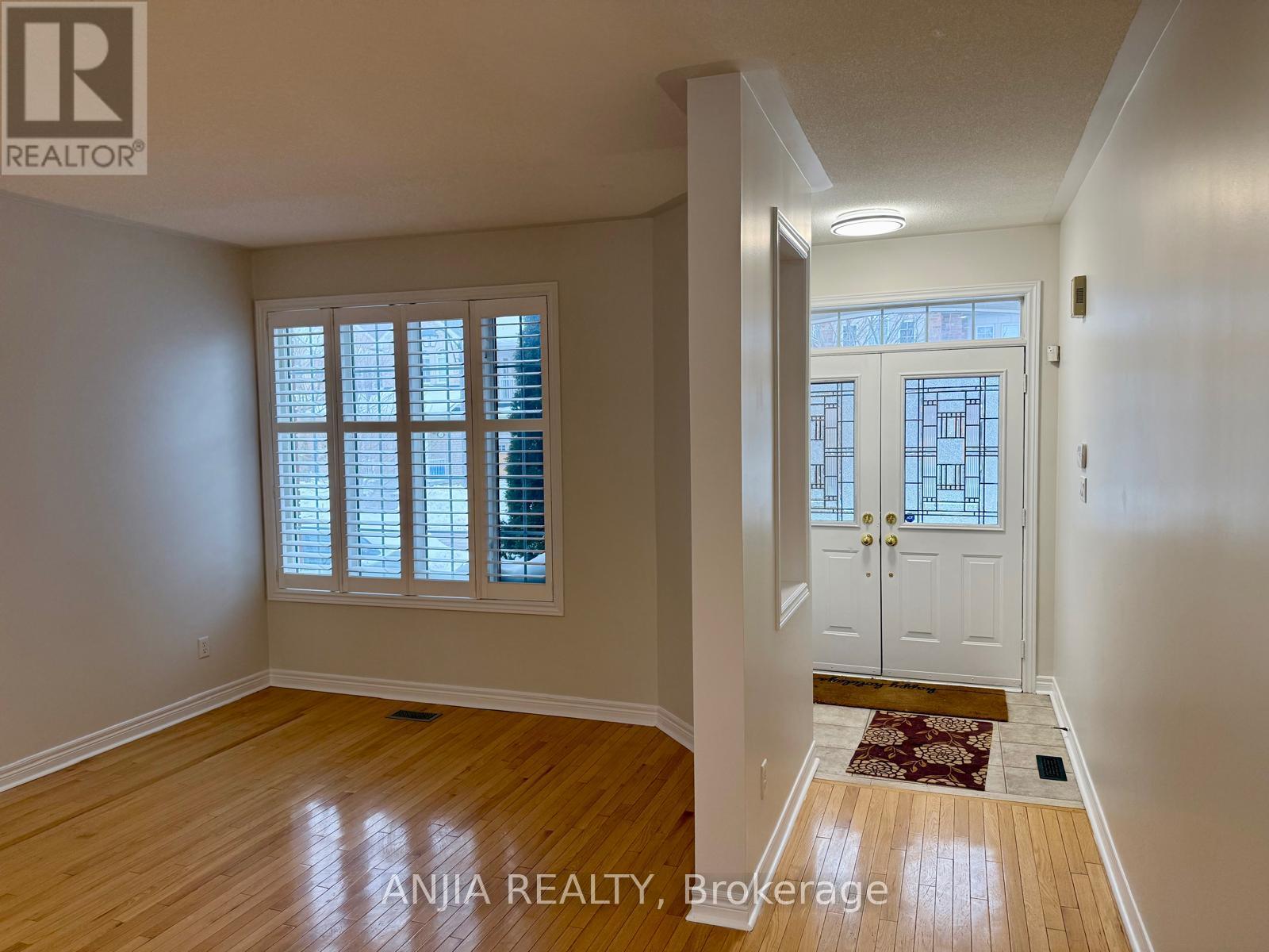 A room with a door and a window with blinds.
