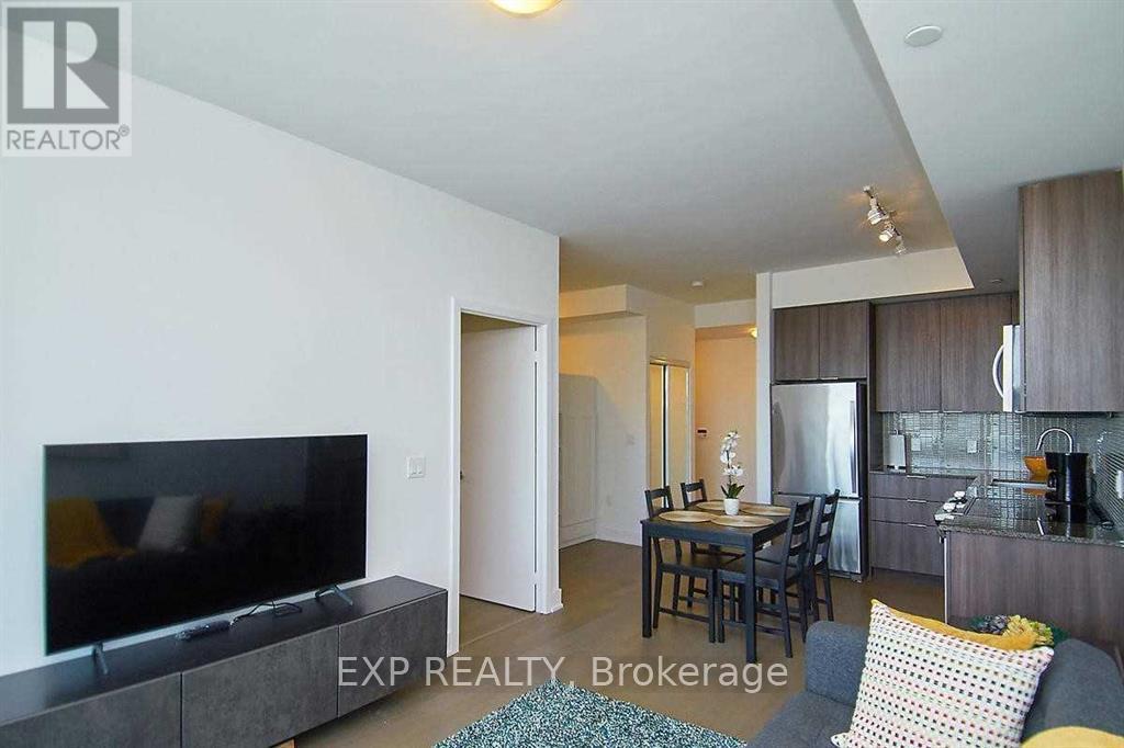 A living room with a grey couch and a television.