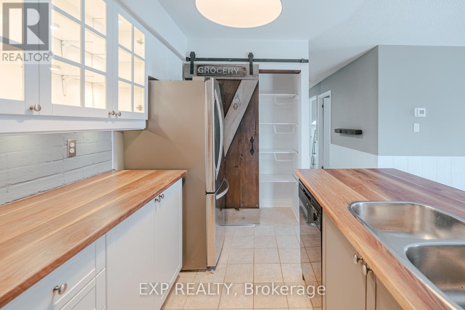 A kitchen with a wooden counter top and white cabinets.