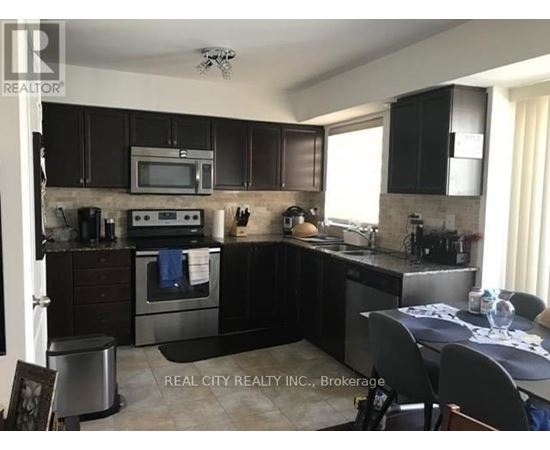 A kitchen with black cabinets and stainless steel appliances.