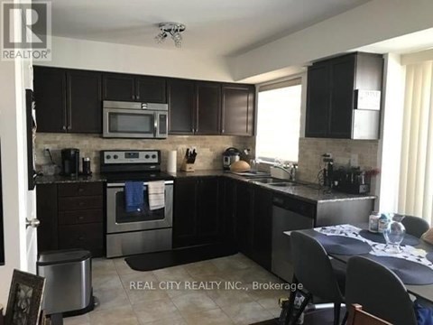 A kitchen with black cabinets and stainless steel appliances.
