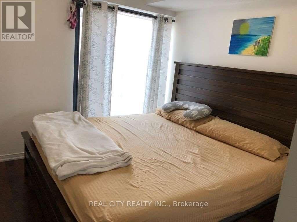 A bedroom with a bed, pillows, and a painting on the wall.