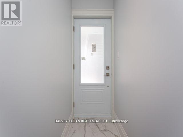 A white door in a room with a brokerage sign on the wall.