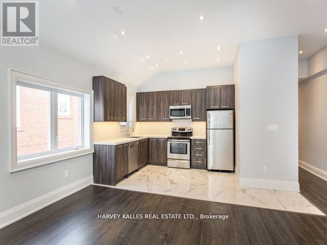 A spacious kitchen with wooden cabinets and stainless steel appliances.