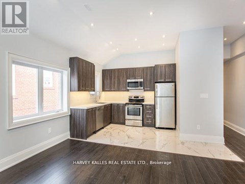 A spacious kitchen with wooden cabinets and stainless steel appliances.