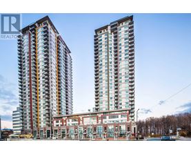 Two tall residential buildings stand next to a building with a glass facade.