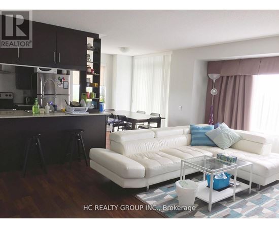 A modern kitchen with a white sofa and a glass coffee table.
