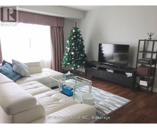 A living room with a Christmas tree and a flat screen TV.