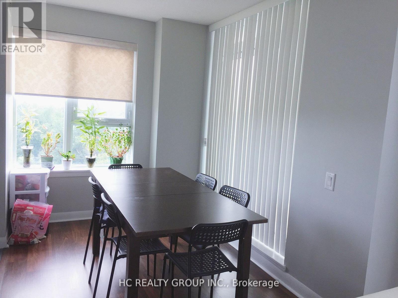 A dining room with a table and chairs.