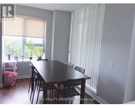 A dining room with a table and chairs.