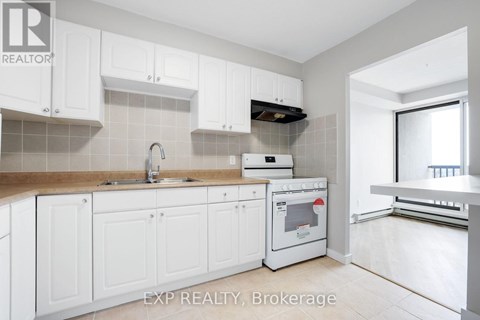 A kitchen with white cabinets and a stove top oven.