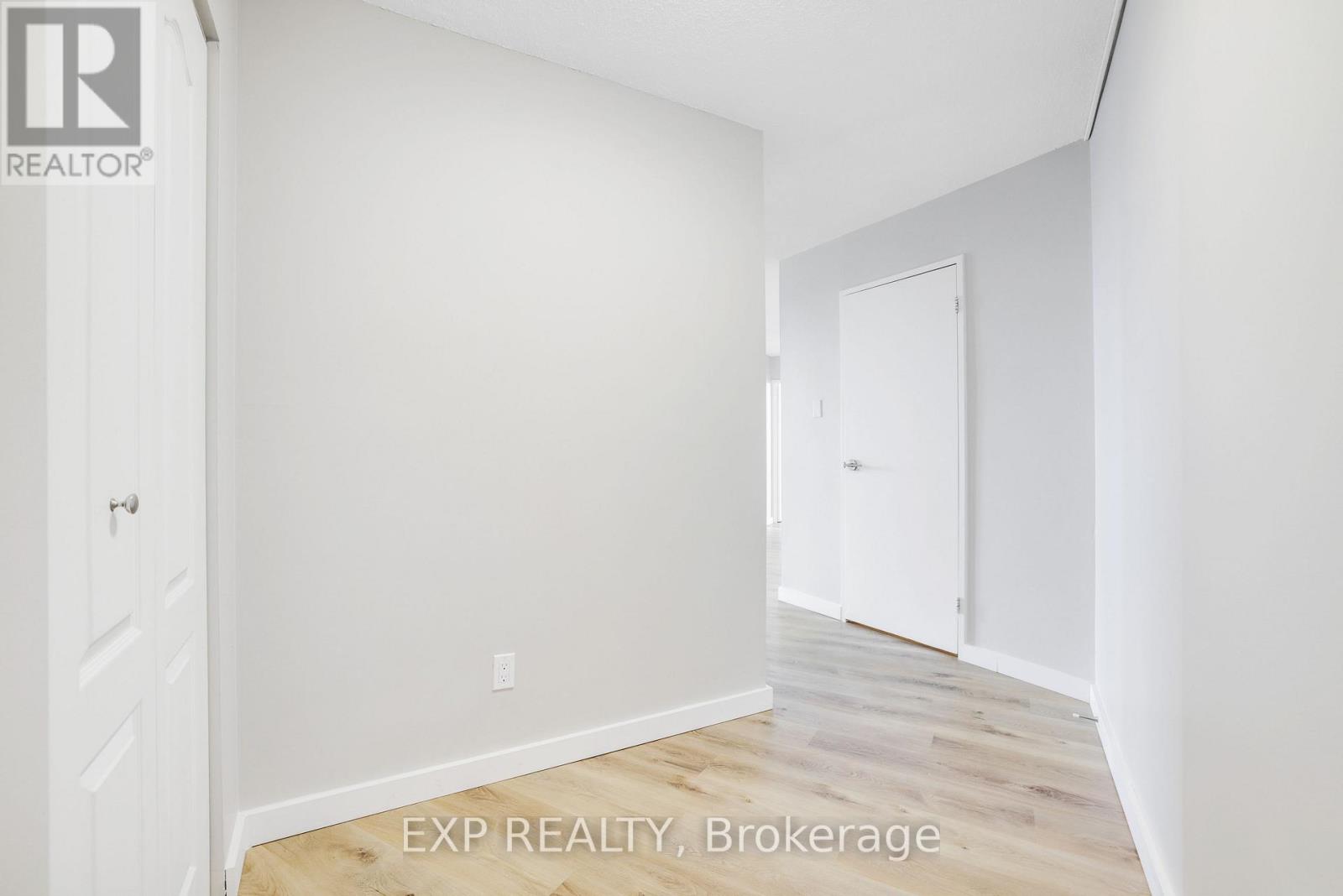 A white room with EXP REALTY, Brokerage written on the floor.