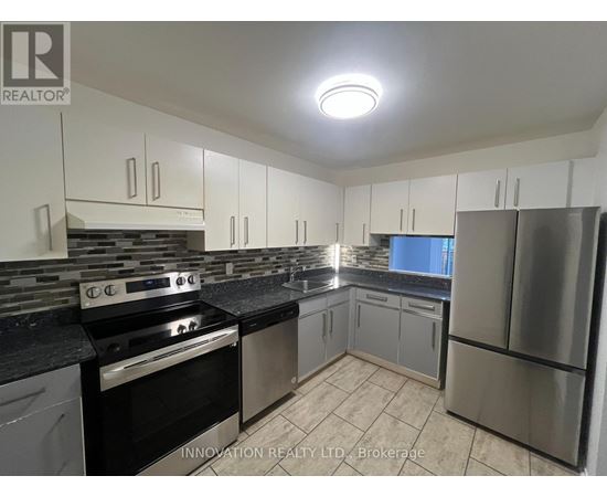 A kitchen with a stove top oven and a refrigerator.