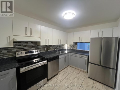 A kitchen with a stove top oven and a refrigerator.