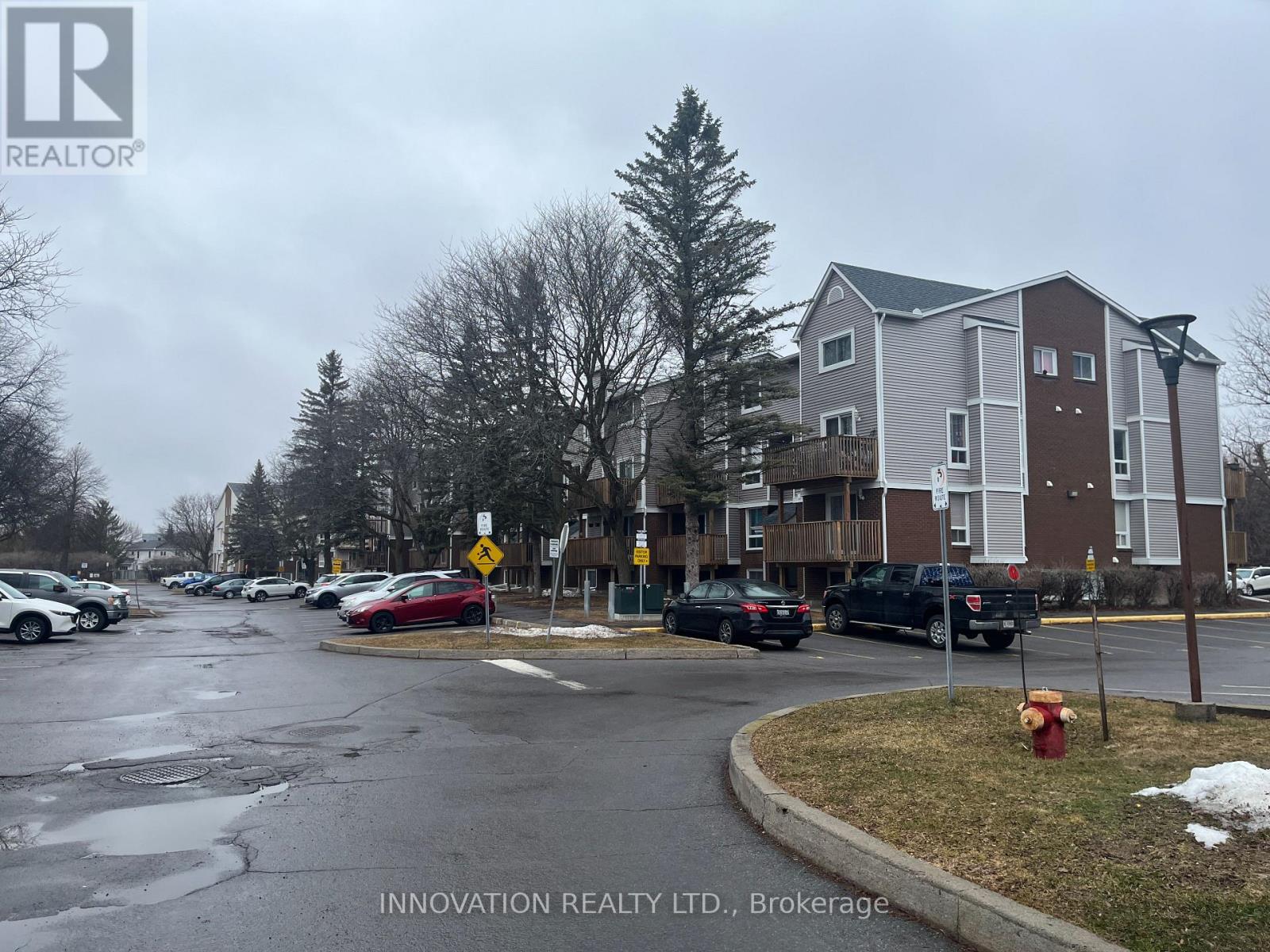 A street view of a residential area with cars parked on the side of the road.