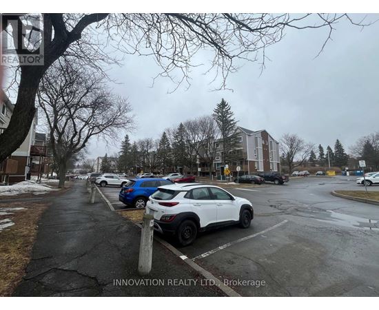 A white car is parked in a parking lot.