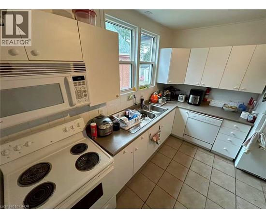 A kitchen with white appliances and a black stove top.