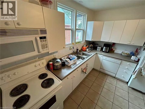 A kitchen with white appliances and a black stove top.