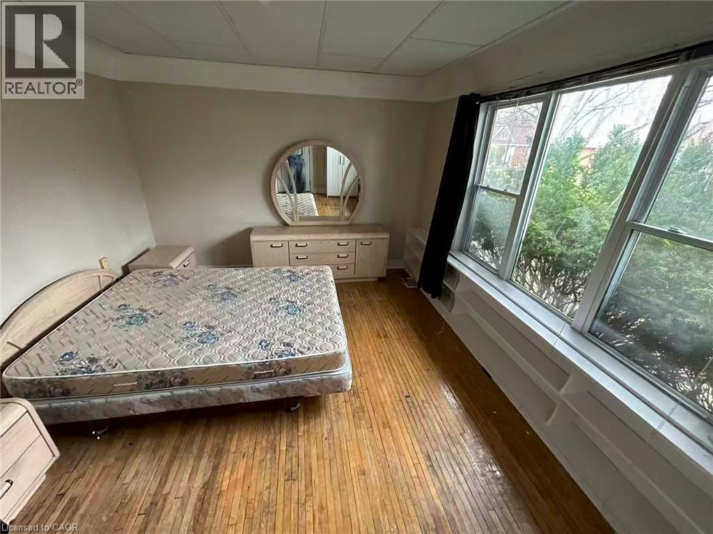 A bedroom with a bed, dresser, and mirror.