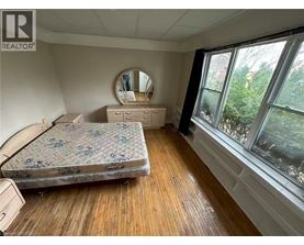 A bedroom with a bed, dresser, and mirror.