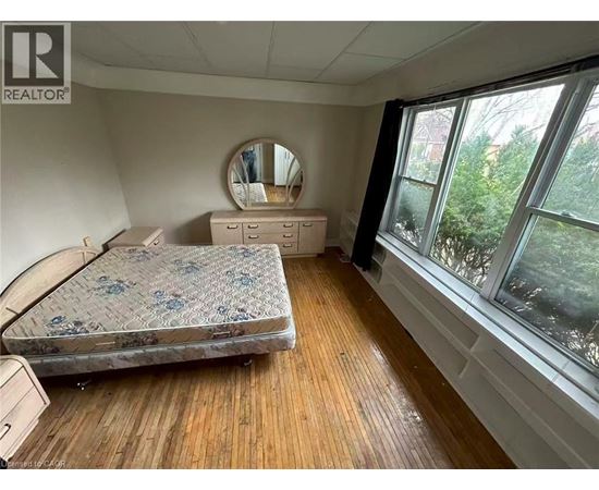 A bedroom with a bed, dresser, and mirror.