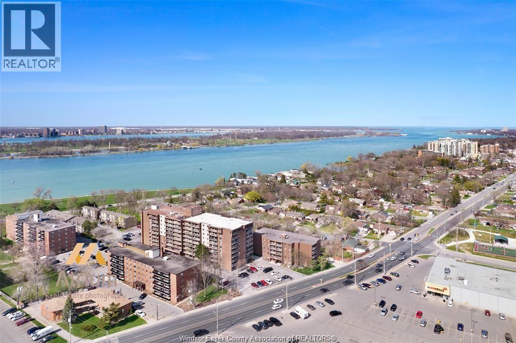 A realtor photo of a city street with a body of water in the background.