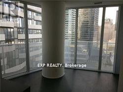 A room with a large window showing a cityscape and a pillar in the middle.