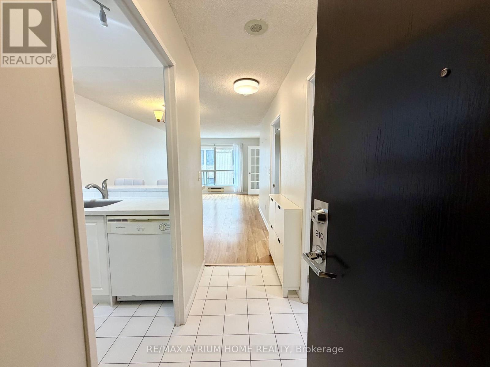 A hallway with a black door on the right and a washing machine in the background.