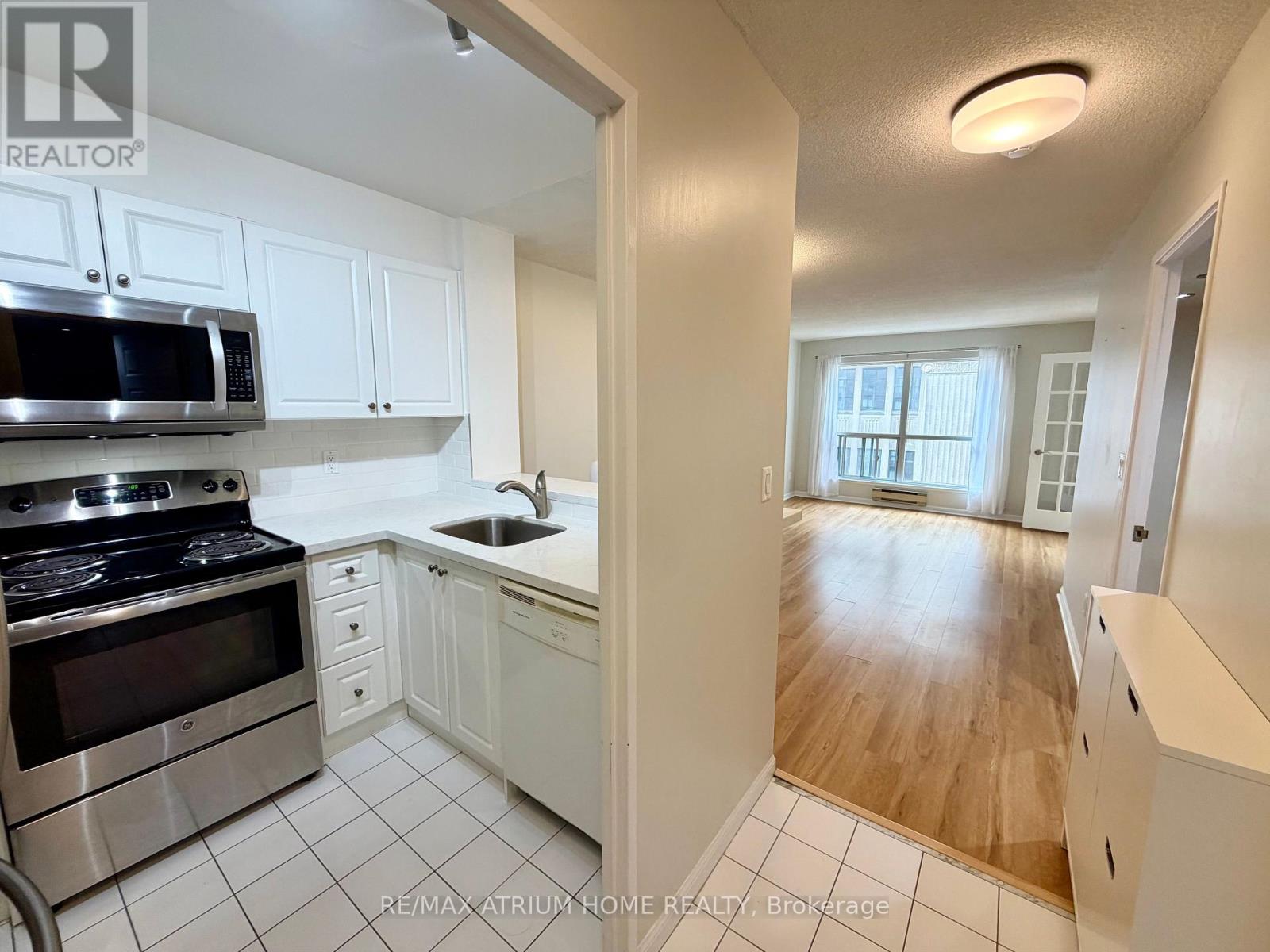 A kitchen with white cabinets and a stainless steel stove top oven.