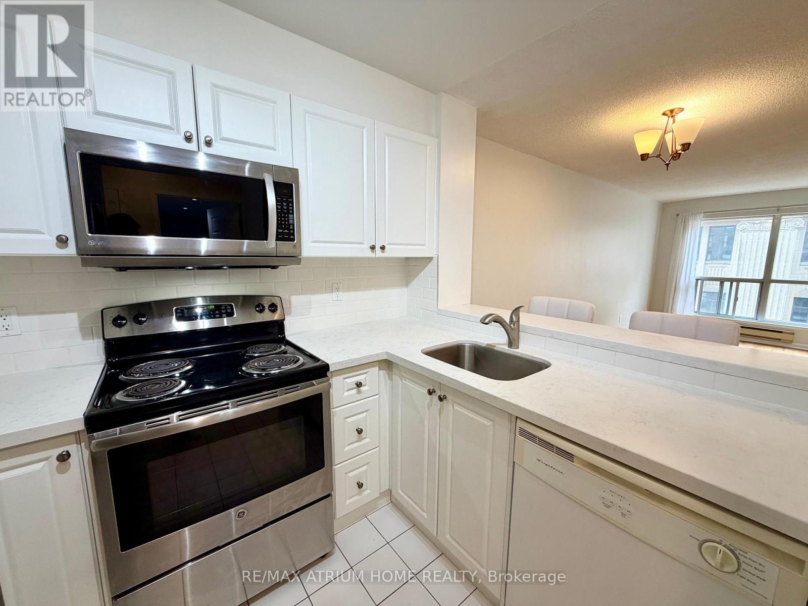 A kitchen with white cabinets and a stove top oven.