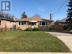 A house with a brown roof and a white fence is for sale.
