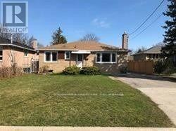 A house with a brown roof and a white fence is for sale.