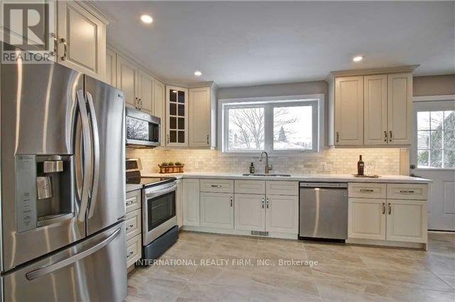A kitchen with stainless steel appliances and white cabinets.
