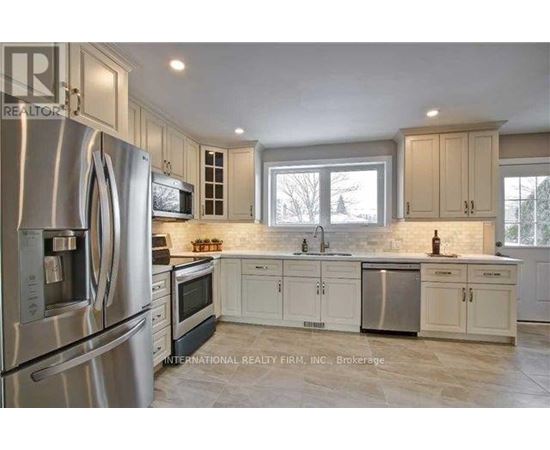 A kitchen with stainless steel appliances and white cabinets.