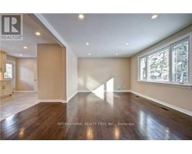 A spacious room with wooden floors and a large window.
