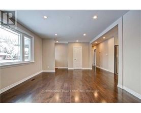 A spacious room with wooden floors and white walls.