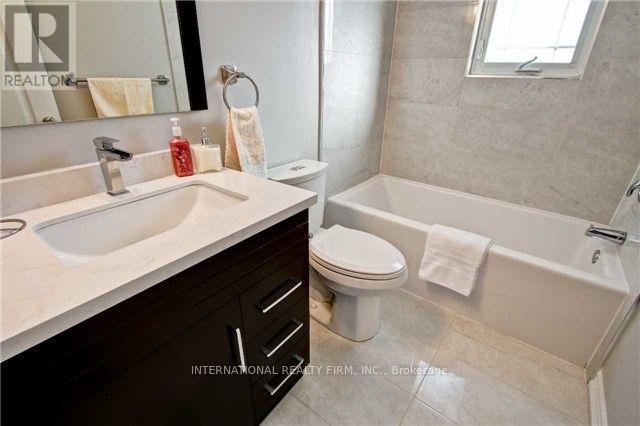 A bathroom with a white sink, toilet, and bathtub.