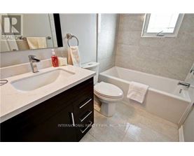A bathroom with a white sink, toilet, and bathtub.