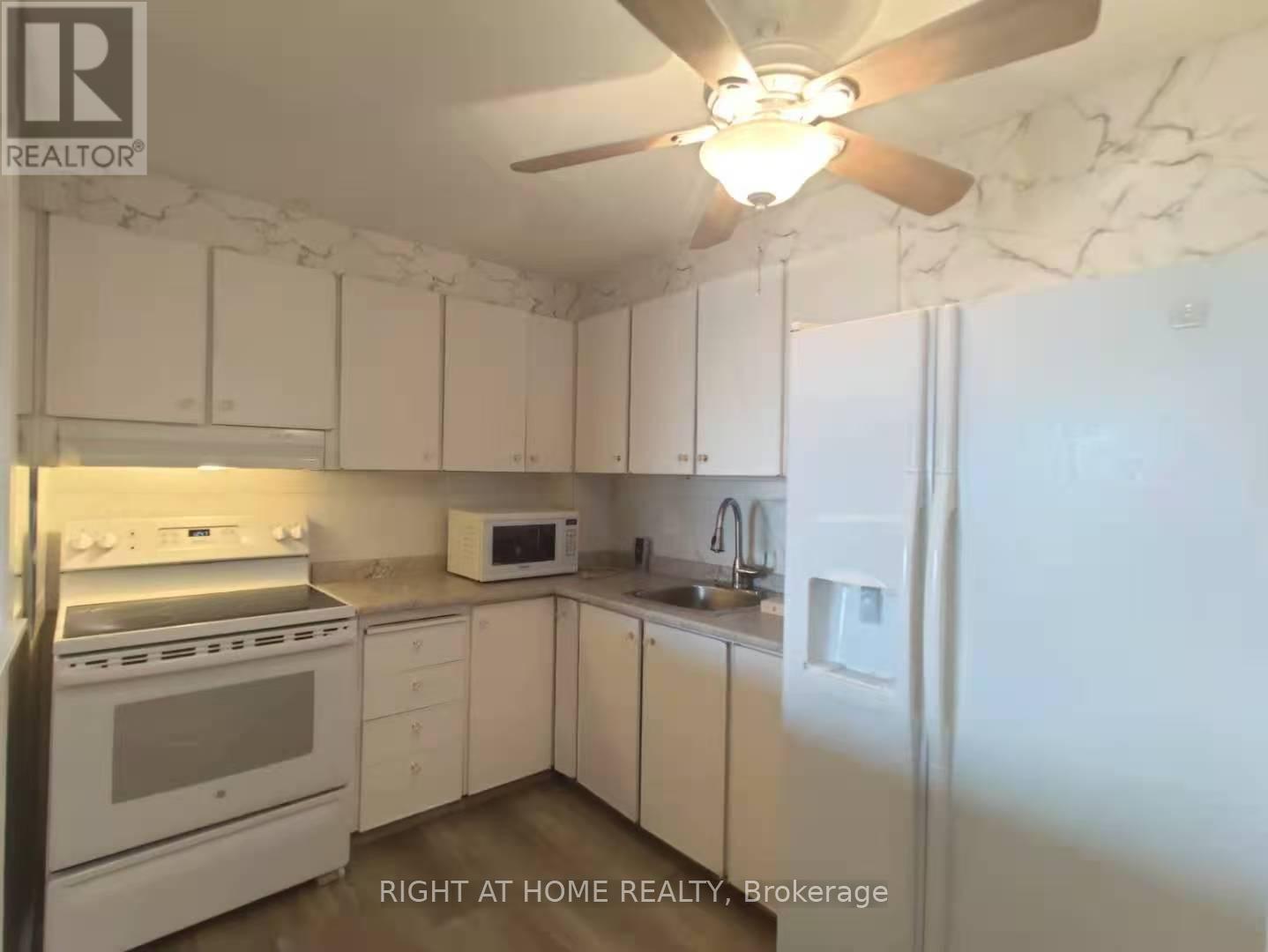 A kitchen with white appliances and cabinets.