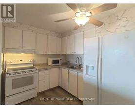 A kitchen with white appliances and cabinets.
