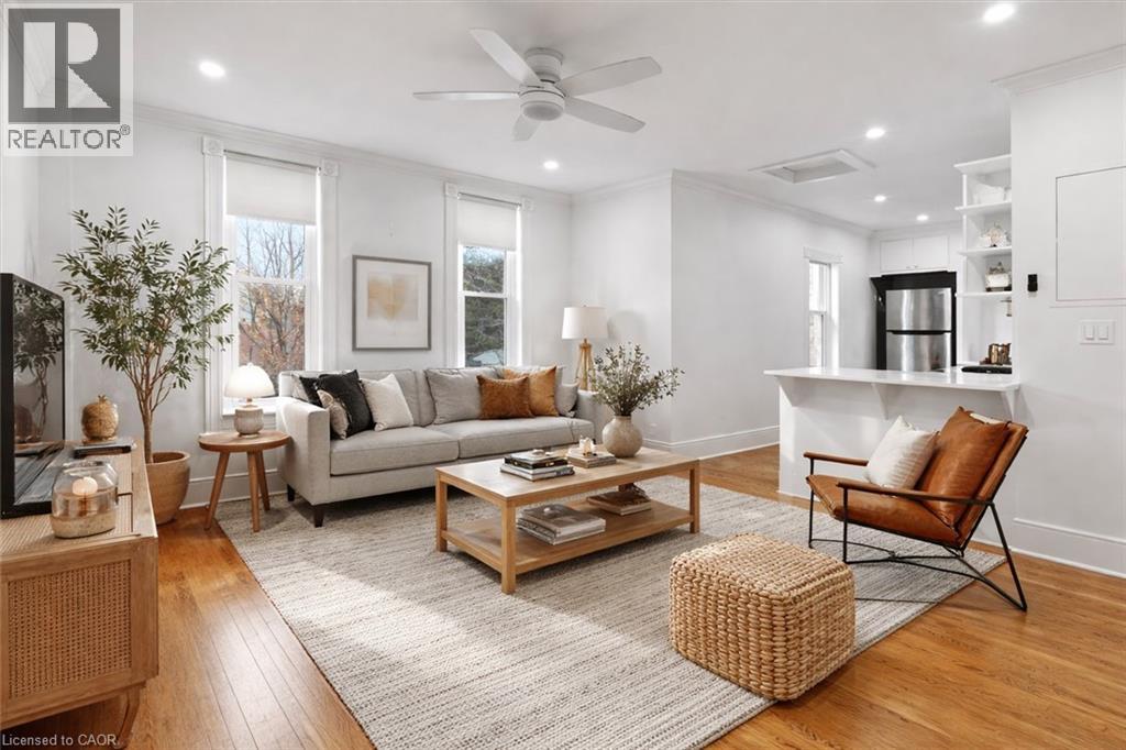 A well-lit living room with a white sofa, wooden coffee table, and a brown chair.