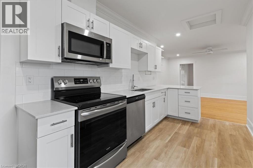 A modern kitchen with white cabinets and stainless steel appliances.