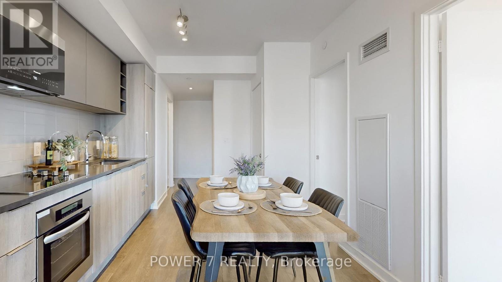 A modern kitchen with a dining table set for two.