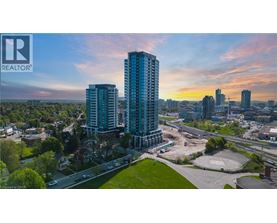 A cityscape with a large building in the foreground and a sunset in the background.