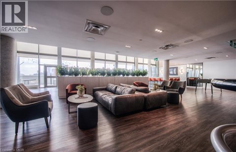 A living room with a brown sofa and a black armchair.