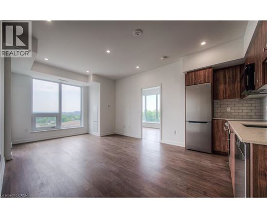 A spacious kitchen with wooden cabinets and a stainless steel refrigerator.