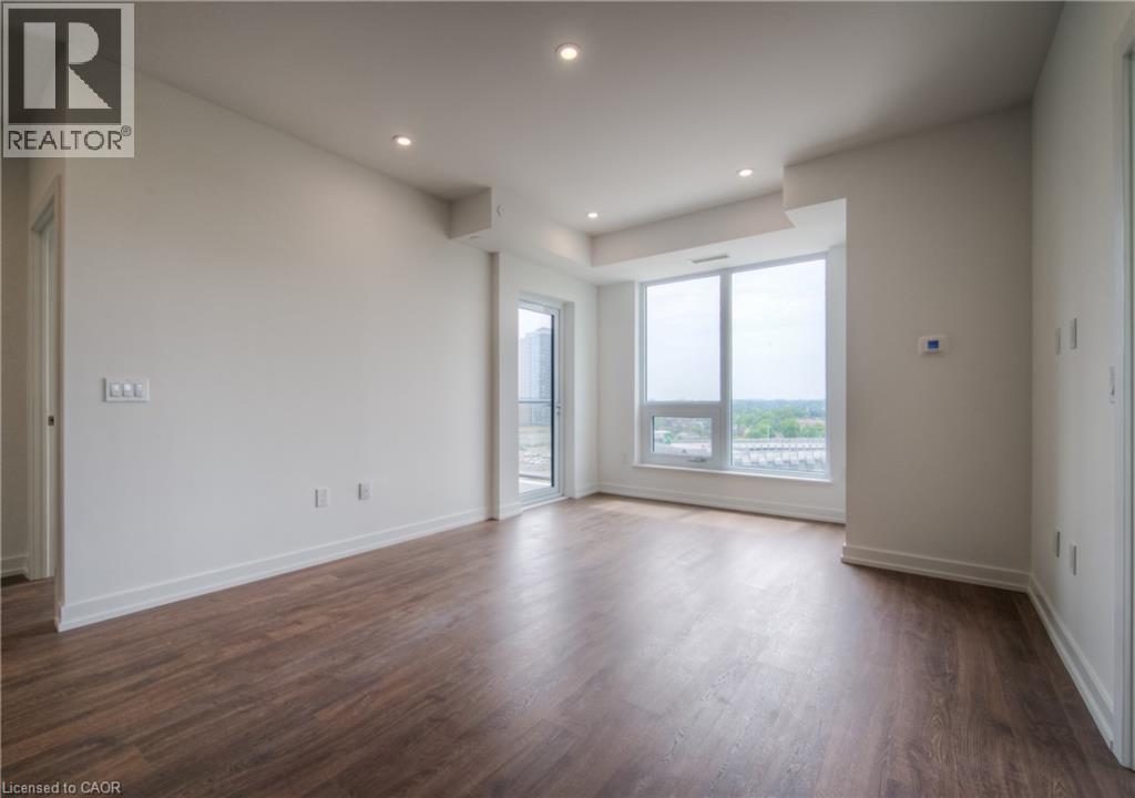 A spacious room with wooden floors and a large window.